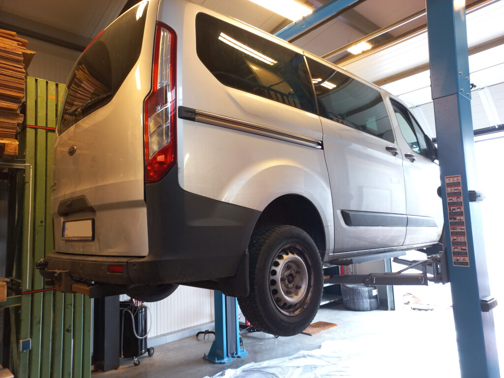 großes Fahrzeug bei Wartungsarbeiten auf einer Hebebühne