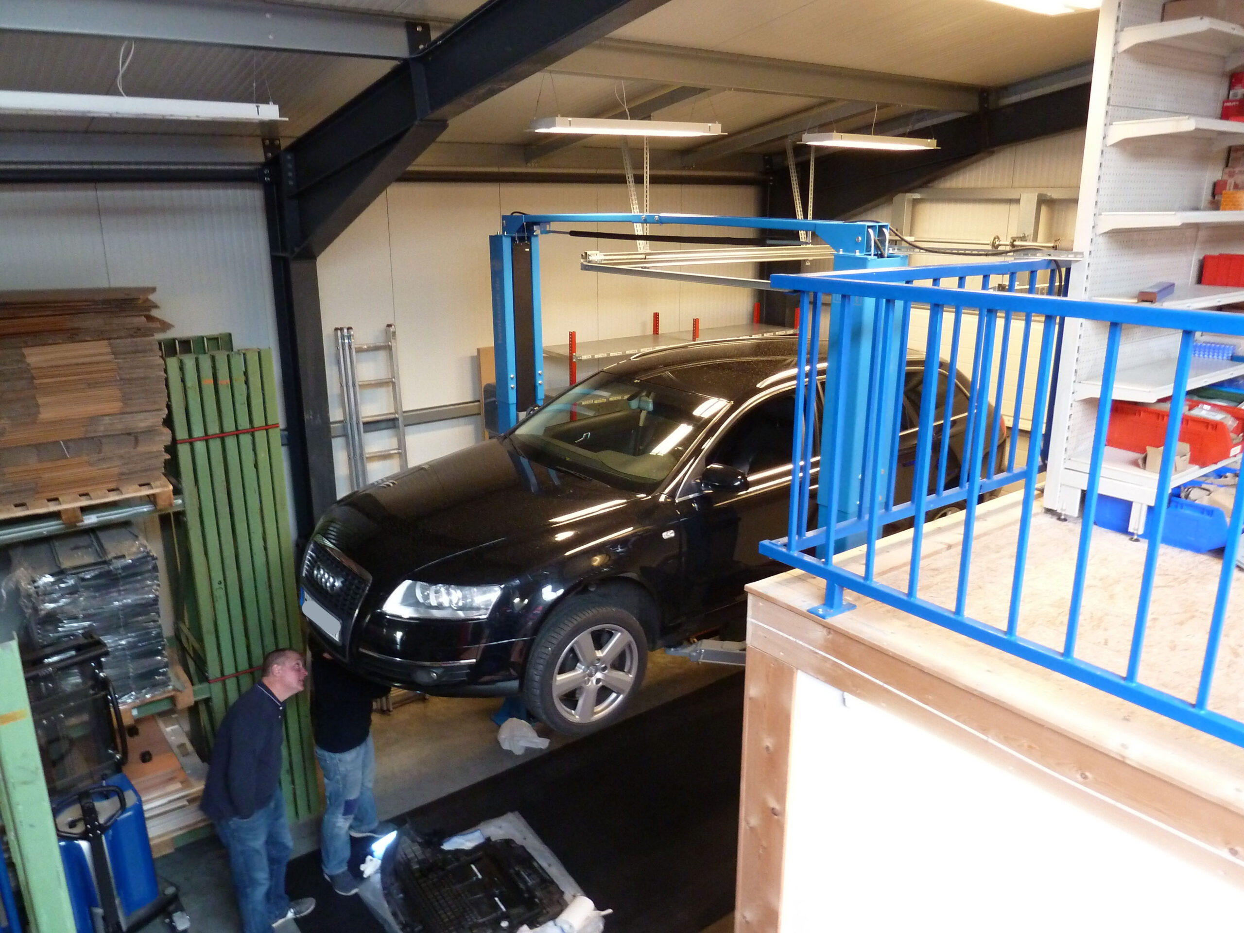 Kunde bei Unterbodenarbeiten an einem Fahrzeug auf einer Hebebühne