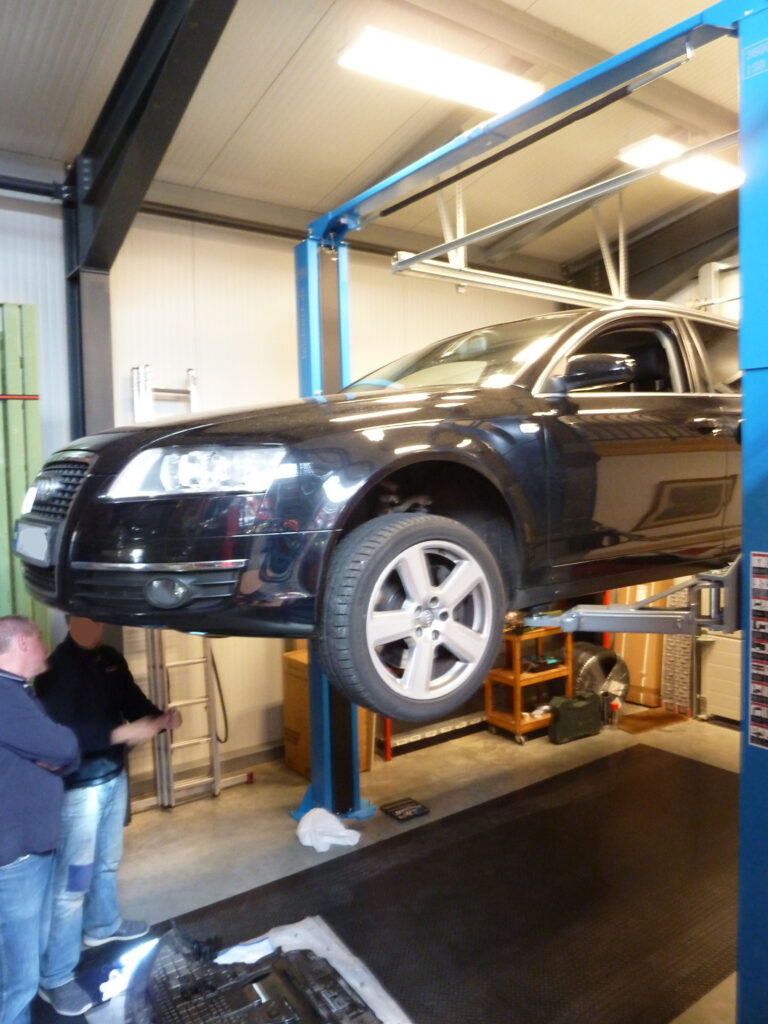 Kunden bei der Inspektion eines Autos auf der Hebebühne von Autoselbsthilfe Lüneburg