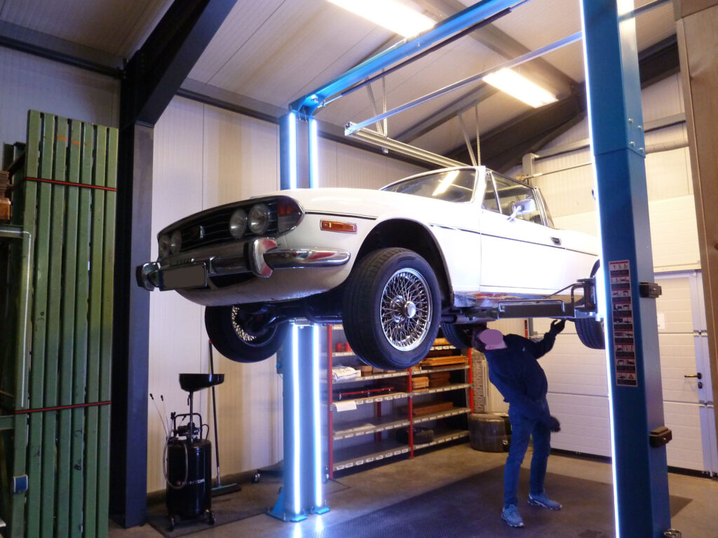 Kunde inspiziert den Unterboden eines Olstimers Kunde inspiziert den Unterboden eines Olstimers