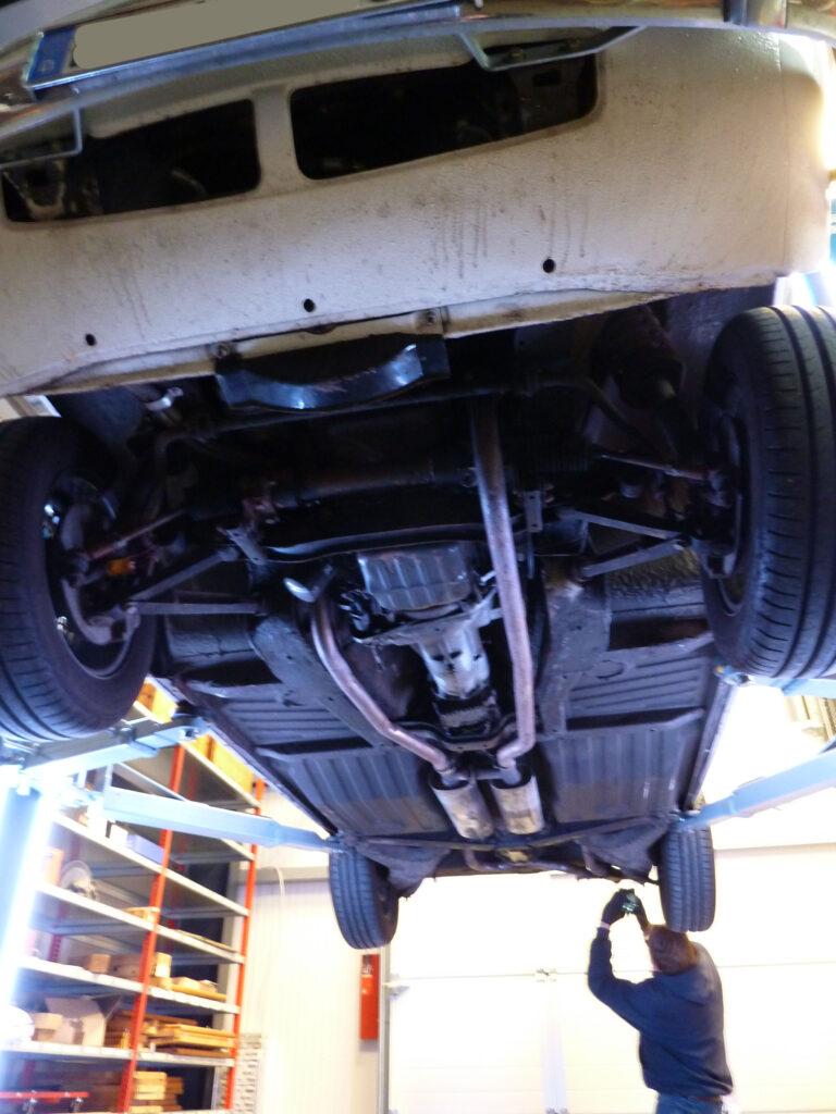 Arbeiten am Unterboden eines PKW auf der Hebebühne